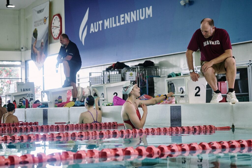 Swimmings standing at the end of a pool